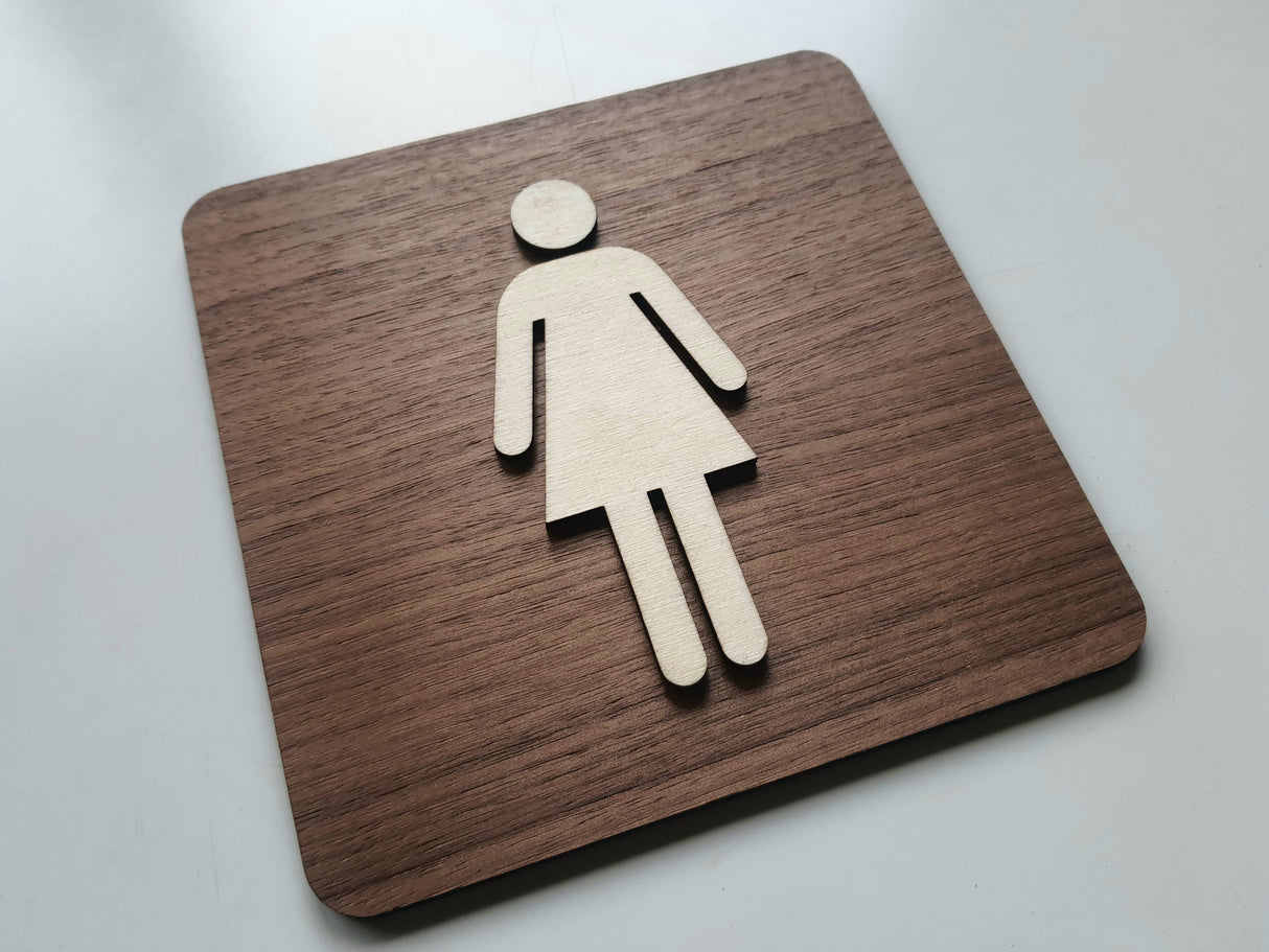 Dametoilet skilt med naturlig træfinish set fra vinkel