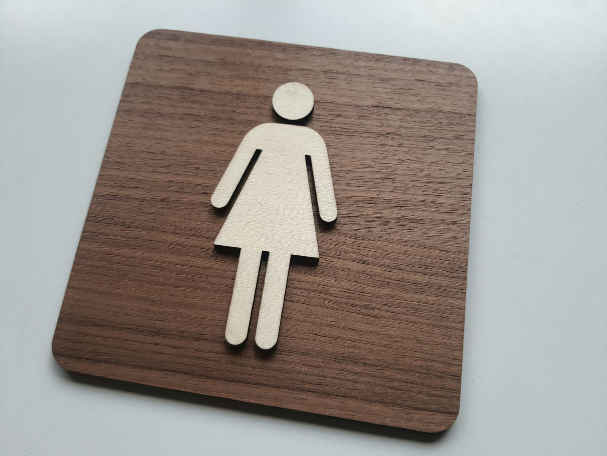 Dametoilet skilt med naturlig træfinish set fra vinkel