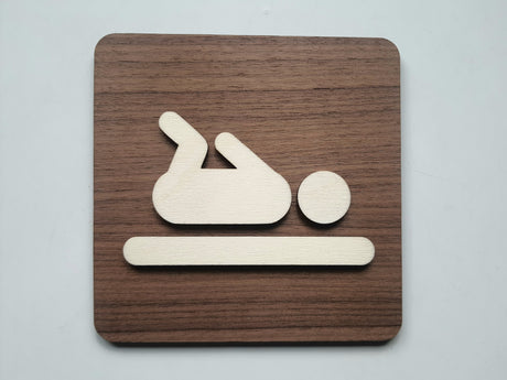 Pusleplads skilt i træ med baby piktogram på valnød baggrund – frontvisning