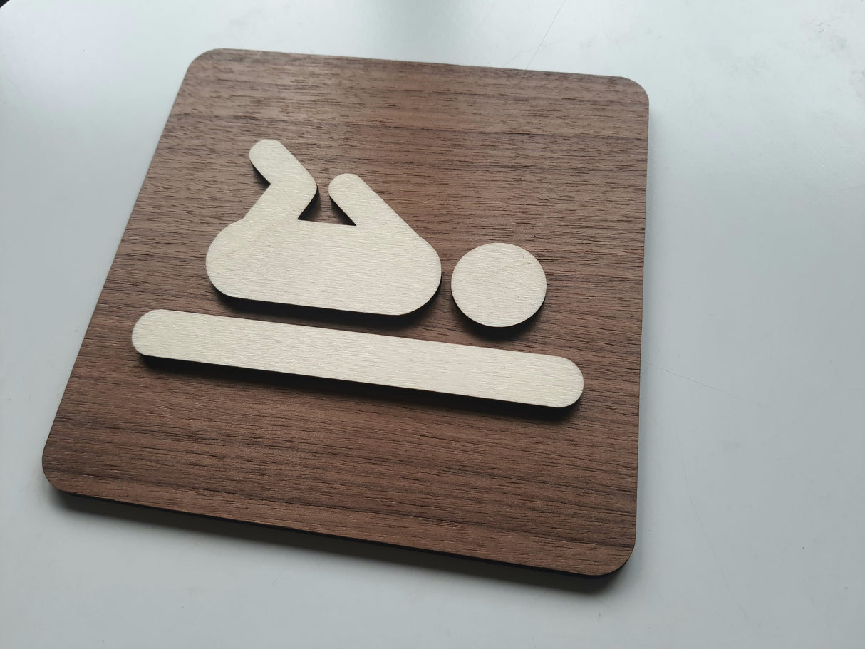 Elegant pusleplads skilt i træ set fra første vinkel med tydeligt piktogram