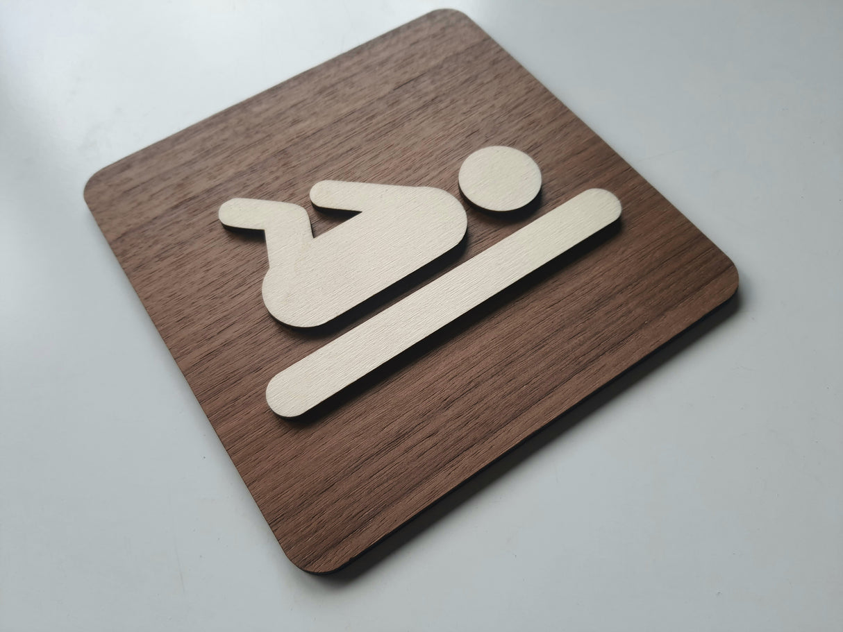 Stilrent pusleplads skilt i valnød set fra anden vinkel – baby symbol til puslerum