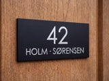 Navneskilt til dør i sort aluminium, selvklæbende, 78 x 30 mm