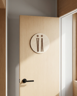 Skygge toiletskilt i træ med dame- og herrepiktogram i birk og valnød monteret på lys toiletdør